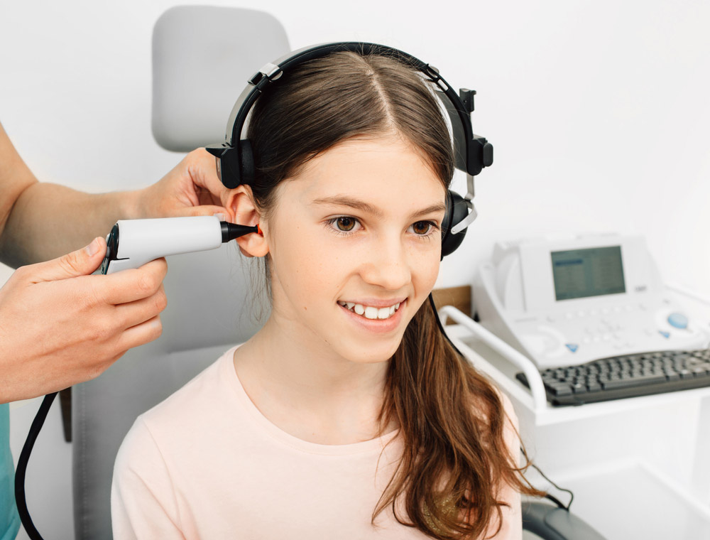 audiologist-doing-hearing-exam-on-girl