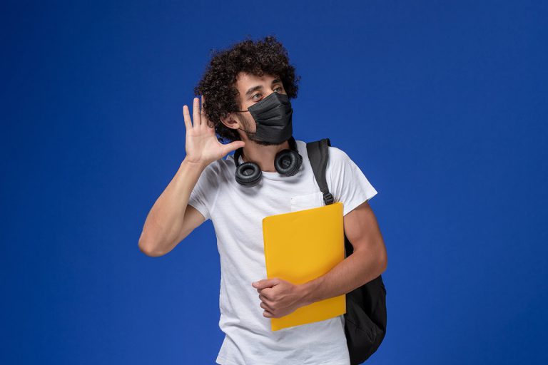 boy-student-black-mask-holding-yellow-files-trying-hear